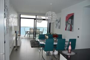 a dining room with a table and green chairs at Sunset Drive Exclusive - Benidorm in Benidorm