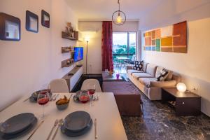 uma sala de estar com um sofá e uma mesa com copos de vinho em Archer - Sea view apartment em Atenas