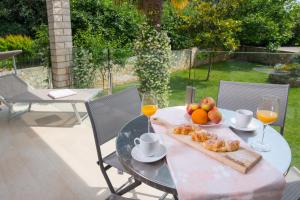 a table with a plate of fruit and two glasses of wine at Apartmani MIRA in Premantura