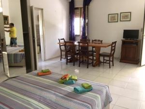 Punta Prosciutto apartments to rent في بونتا بروسسيوتو: غرفة بها طاولة وسرير عليه مناشف