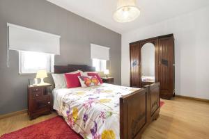 1 dormitorio con 1 cama con colcha de flores en Casa do Porto Carreiro, en Oliveira de Azemeis
