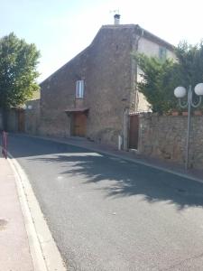 Laure-MinervoisにあるChambre d'Hôtes le massanousの前方の道路のある古い石造りの建物