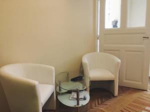 a room with two chairs and a glass table at Adrienn apartment in Budapest