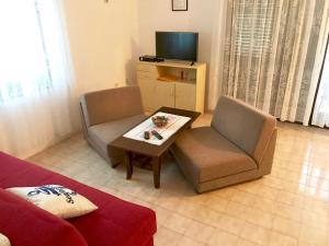 ein Wohnzimmer mit einem Sofa, einem Tisch und einem TV in der Unterkunft Apartments Markelj in Lovrečica