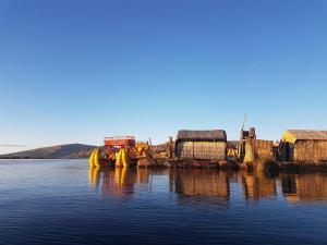 un barco está sentado en un cuerpo de agua en Uros Lake Titicaca Lodge, en Puno