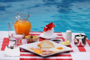 a plate of food on a table next to a pool at Piedras Blancas Lodge in Puerto Ayora