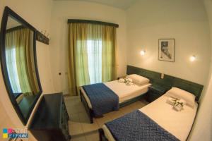 a hotel room with two beds and a mirror at The L Villa in Nea Peramos