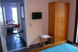 a room with a bedroom with a bed and a tv at Vivi Apartments in Iraklitsa