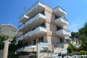 a building with balconies and umbrellas in front of it at Vivi Apartments in Iraklitsa