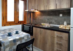 a kitchen with a sink and a counter with a table at Apartments Konstantinidis in Nea Potidaea