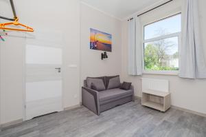 a living room with a chair and a window at Zefiro Stajenna in Gdańsk