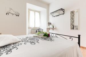 ローマにあるPinerolo Tourist Accommodationの白と黒のベッドが備わる白のベッドルーム1室