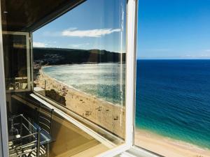 Blick auf den Strand aus dem Fenster in der Unterkunft Sesimbra Sun Bay in Sesimbra