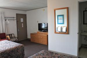 um quarto de hotel com uma cama e uma televisão numa cómoda em Budget Host Crestview Inn em Sault Ste. Marie