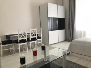 ブダペストにあるHestia Apartmentのベッドルーム1室(ベッド1台、ガラスのテーブル、ダイニングルーム付)