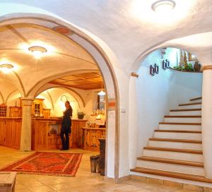 a woman standing in a room with a staircase at Haus Tirol in Molini di Tures