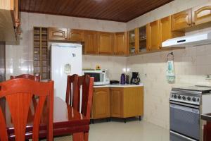 a kitchen with wooden cabinets and a white refrigerator at Casa de Lazer em Campos do Jordao in Campos do Jordão