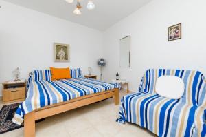 1 Schlafzimmer mit 2 Betten mit blauen und weißen Streifen in der Unterkunft Rooms Roza in Vrboska