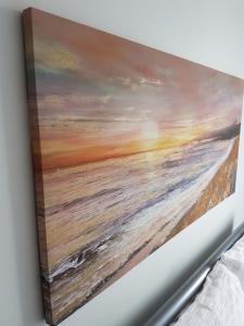 a painting of the ocean on a wall at Leeds City Centre Apartments in Leeds