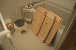 a bathroom with a wooden cabinet and a sink at Spr Guesthouse in Shirahama
