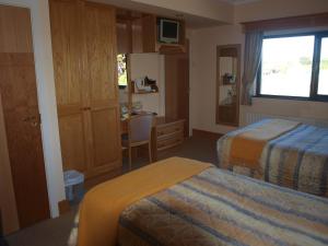 a hotel room with two beds and a desk at Shelmalier House in Athlone