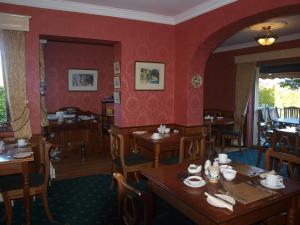 a dining room with wooden tables and red walls at Shelmalier House in Athlone