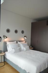1 dormitorio con 1 cama blanca grande y 2 lámparas en Camões by Trindade Sweet Home, en Oporto