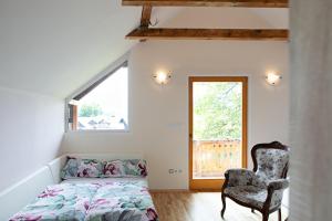 1 dormitorio con 1 cama, 1 silla y 1 ventana en Apartments Nina, en Bled