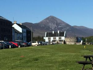 a building with a mountain in the background with cars parked at The Anchorage in Westport