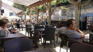 a man and woman sitting at tables in a restaurant at Ericeira Beach Haven in Ericeira