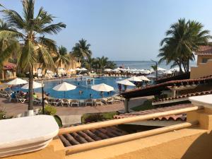 a view of a resort with a swimming pool and the ocean at Villa 18 Con Playa 3 Recamaras dentro de Hotel en Ixtapa in Ixtapa