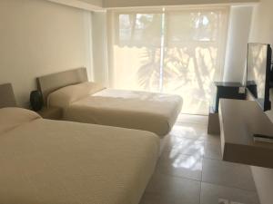 a hotel room with two beds and a window at Villa 18 Con Playa 3 Recamaras dentro de Hotel en Ixtapa in Ixtapa
