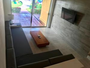 a living room with a couch and a tv at Villa 18 Con Playa 3 Recamaras dentro de Hotel en Ixtapa in Ixtapa