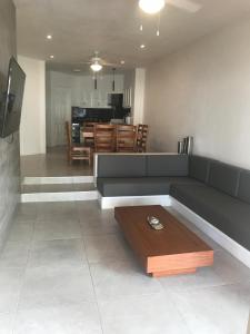 a living room with a couch and a table at Villa 18 Con Playa 3 Recamaras dentro de Hotel en Ixtapa in Ixtapa