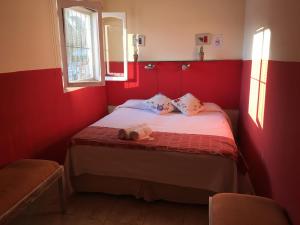 un dormitorio rojo con una cama con un animal de peluche en La Posada del Parque en Salta