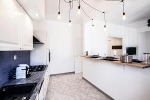 a kitchen with white cabinets and a counter top at Place au Manege in Marseille
