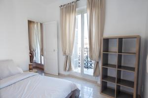 a bedroom with a bed and a window with a balcony at Place au Manege in Marseille