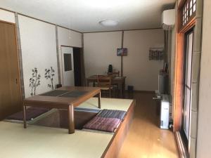 un soggiorno con tavolo e una sala da pranzo di Takayama Ninja House a Takayama
