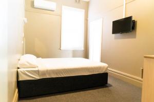 Un pat sau paturi într-o cameră la Swansea Hotel