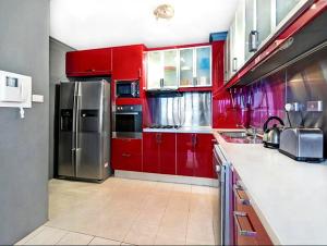 a kitchen with red cabinets and a stainless steel refrigerator at Ausmine Sydney CBD 2Bedroom Apt in Sydney
