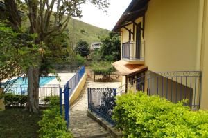 a house with a blue fence next to a swimming pool at Chácara Martinez in Conservatória