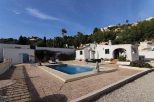 un patio trasero con piscina y una casa en Casa Ian, en Moraira