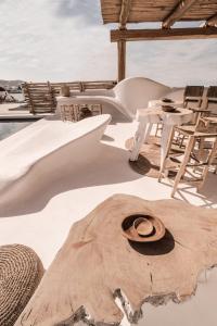 
a wooden bench sitting on top of a sandy beach at MyCocoon Hostel in Mikonos
