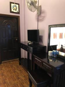 Cette chambre comprend un bureau avec une télévision et un miroir. dans l'établissement Soutjai Guesthouse & Restaurant, à Vang Vieng