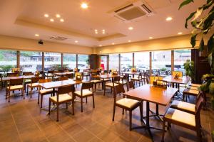 a restaurant with tables and chairs and windows at Hotel Business Inn Yamada in Funakoshi