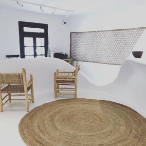 una habitación con 2 sillas y una alfombra en el suelo en MyCocoon Hostel en Mykonos ciudad