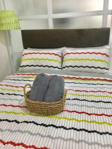 a basket of towels sitting on a bed with pillows at Sofia's Tagaytay Getaway in Tagaytay +18 photos
