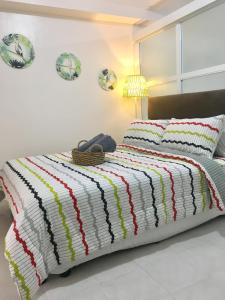 una camera da letto con un letto con una coperta colorata a righe di Sofia's Tagaytay Getaway a Tagaytay