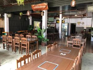 Soutjai Guesthouse & Restaurant في فانغ فينغ: مطعم به طاولة وكراسي خشبية كبيرة