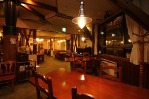 un comedor con mesas de madera y sillas en un restaurante en Petit Resort Hotel Der Barte, en Zao Onsen
